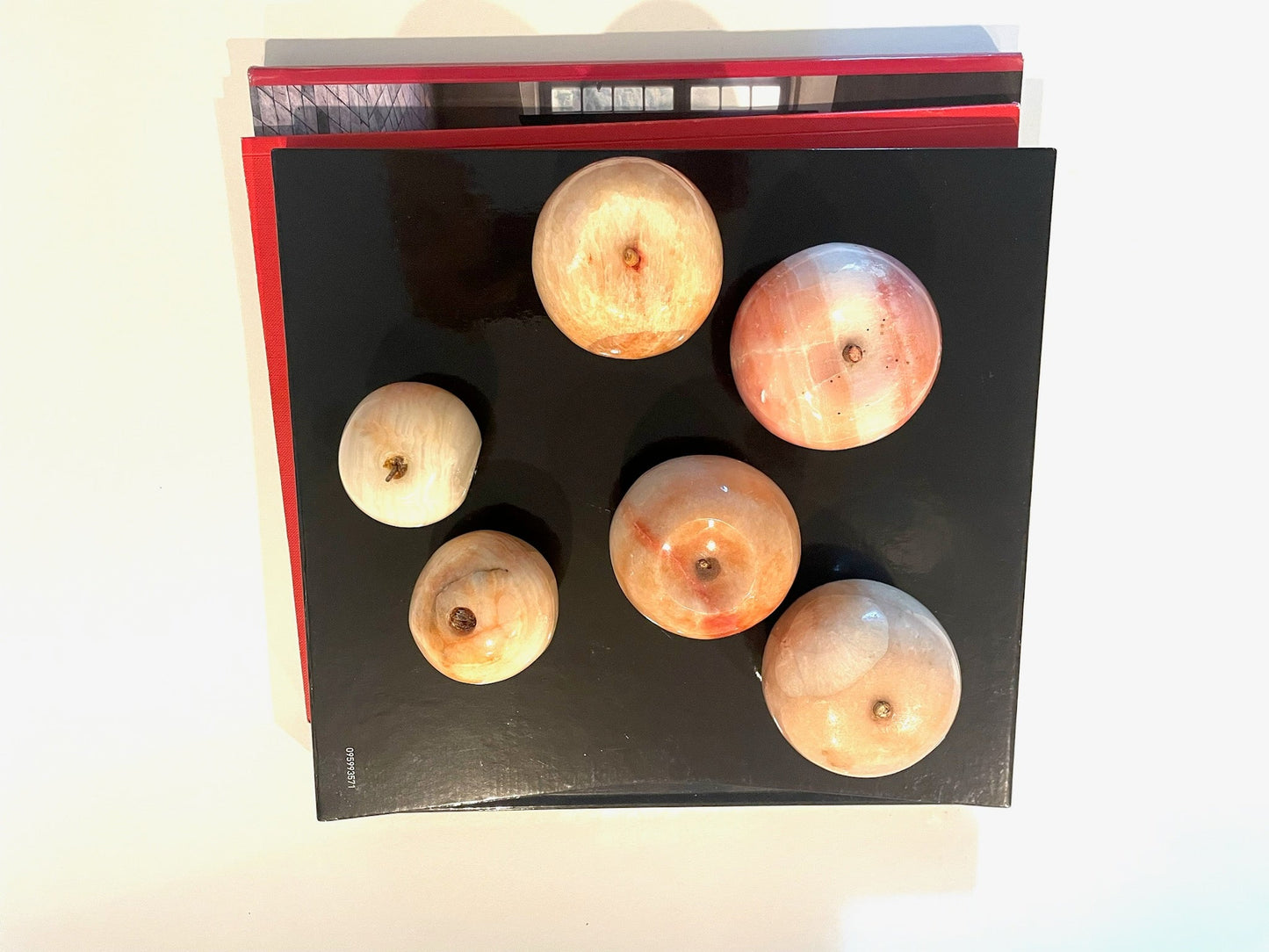 A collection of decorative stone marble fruits with stems