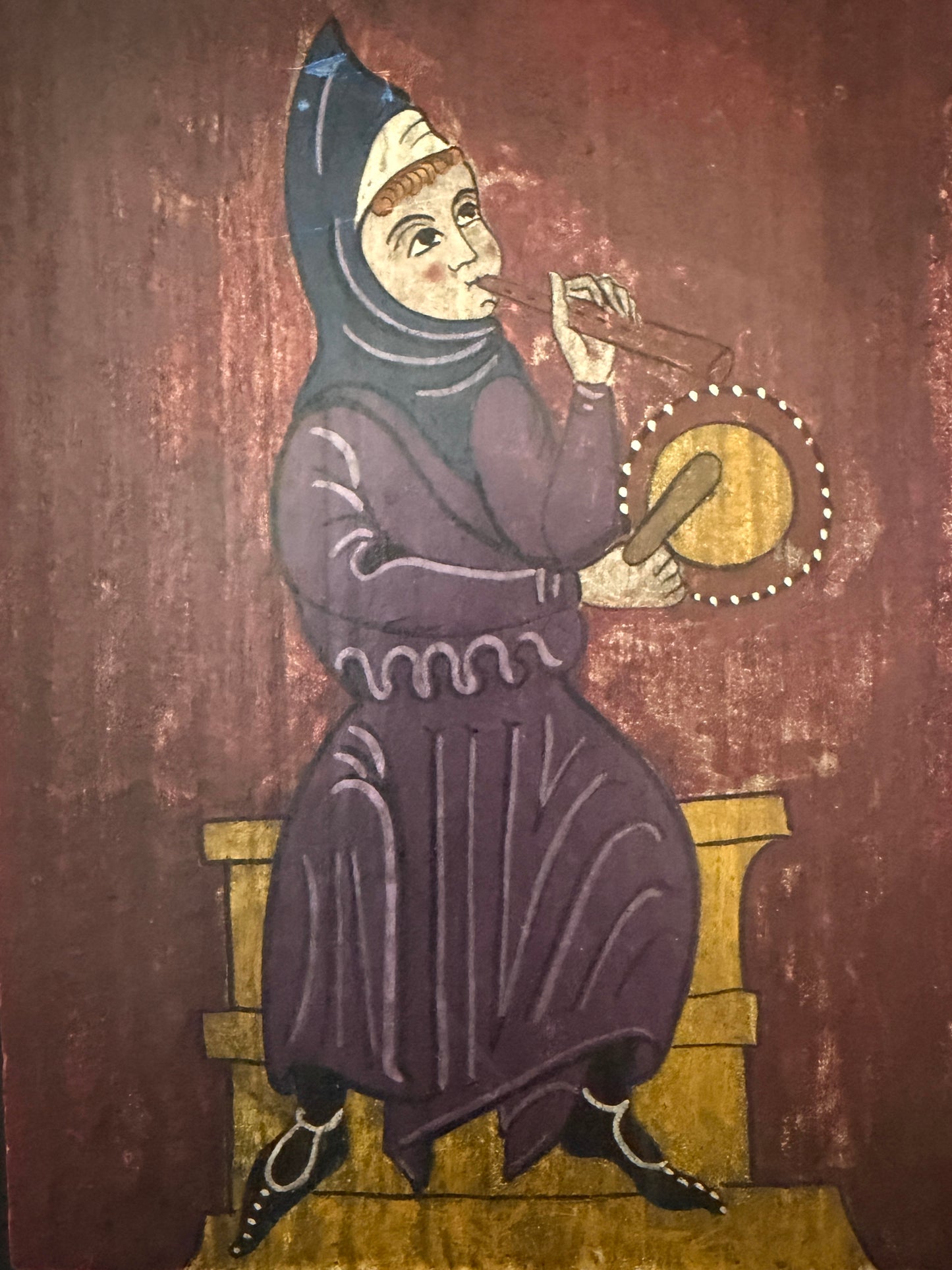 Medieval illustration of a woman playing a lyre on a wooden stool.