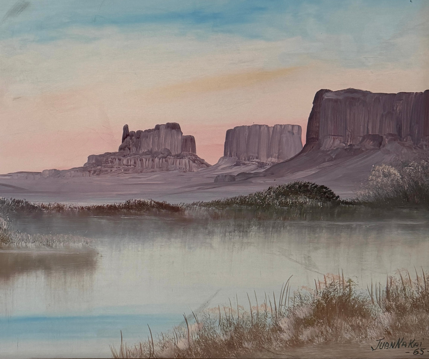 Juan Nakai signed landscape painting depicting a serene river or lake with misty banks, distant butte formations, and a pale sky