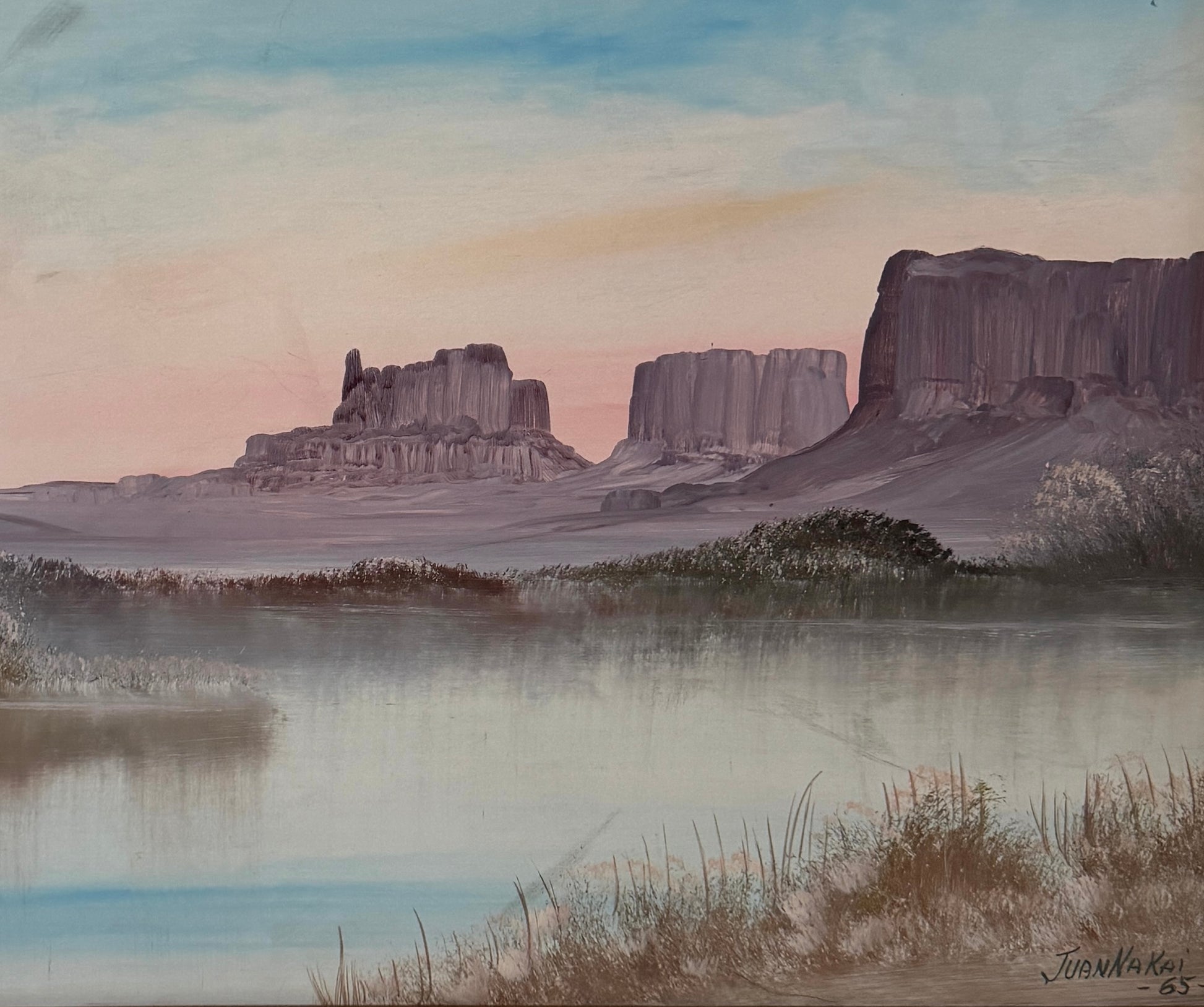 Juan Nakai signed landscape painting depicting a serene river or lake with misty banks, distant butte formations, and a pale sky