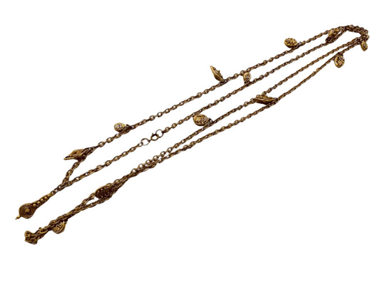 A vintage golden link chain necklace with various charms attached along the length