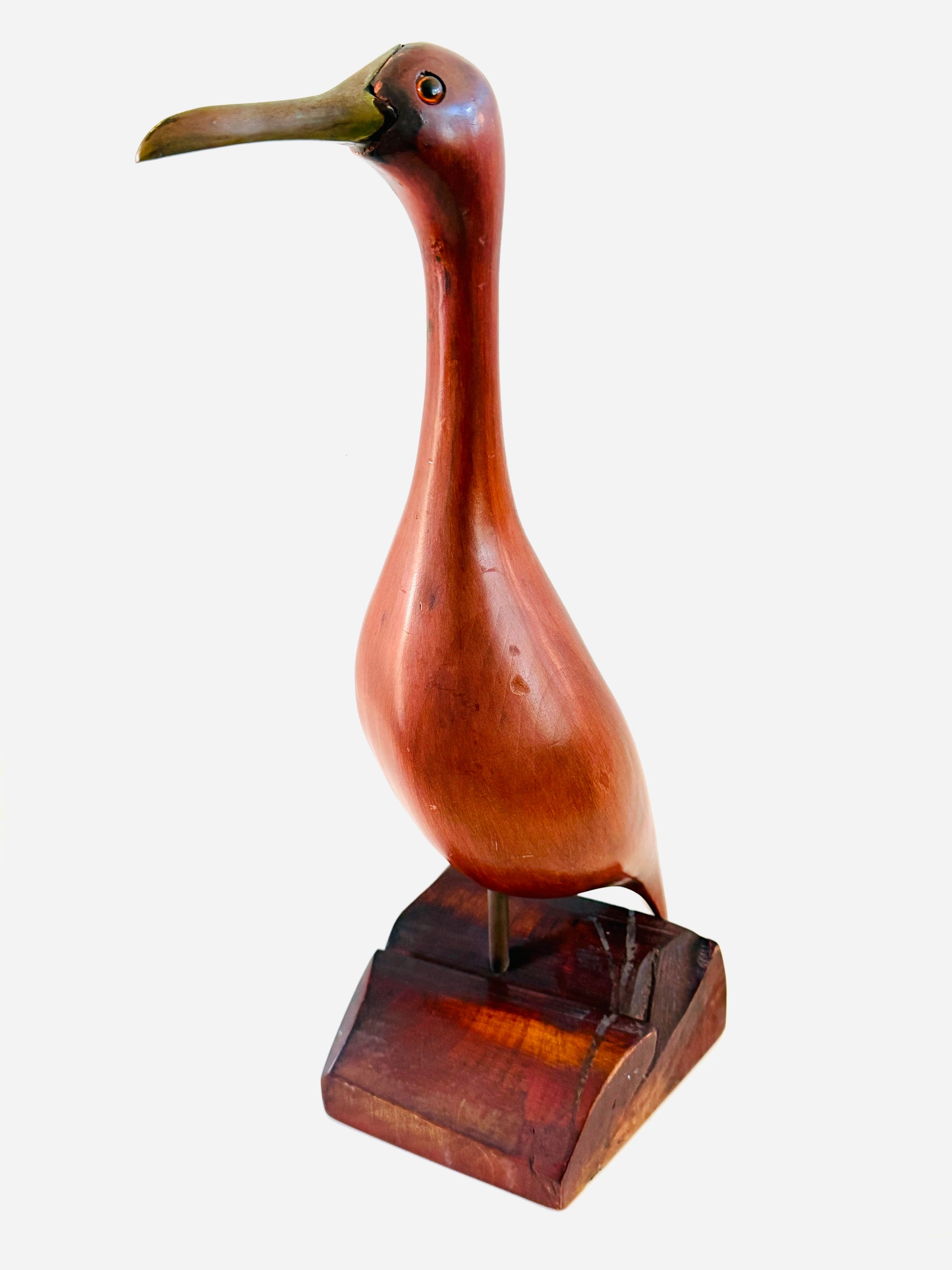 A polished  Mahogany Mid Century Modern sculpture of a long-beaked bird standing on a rectangular wood stand 
