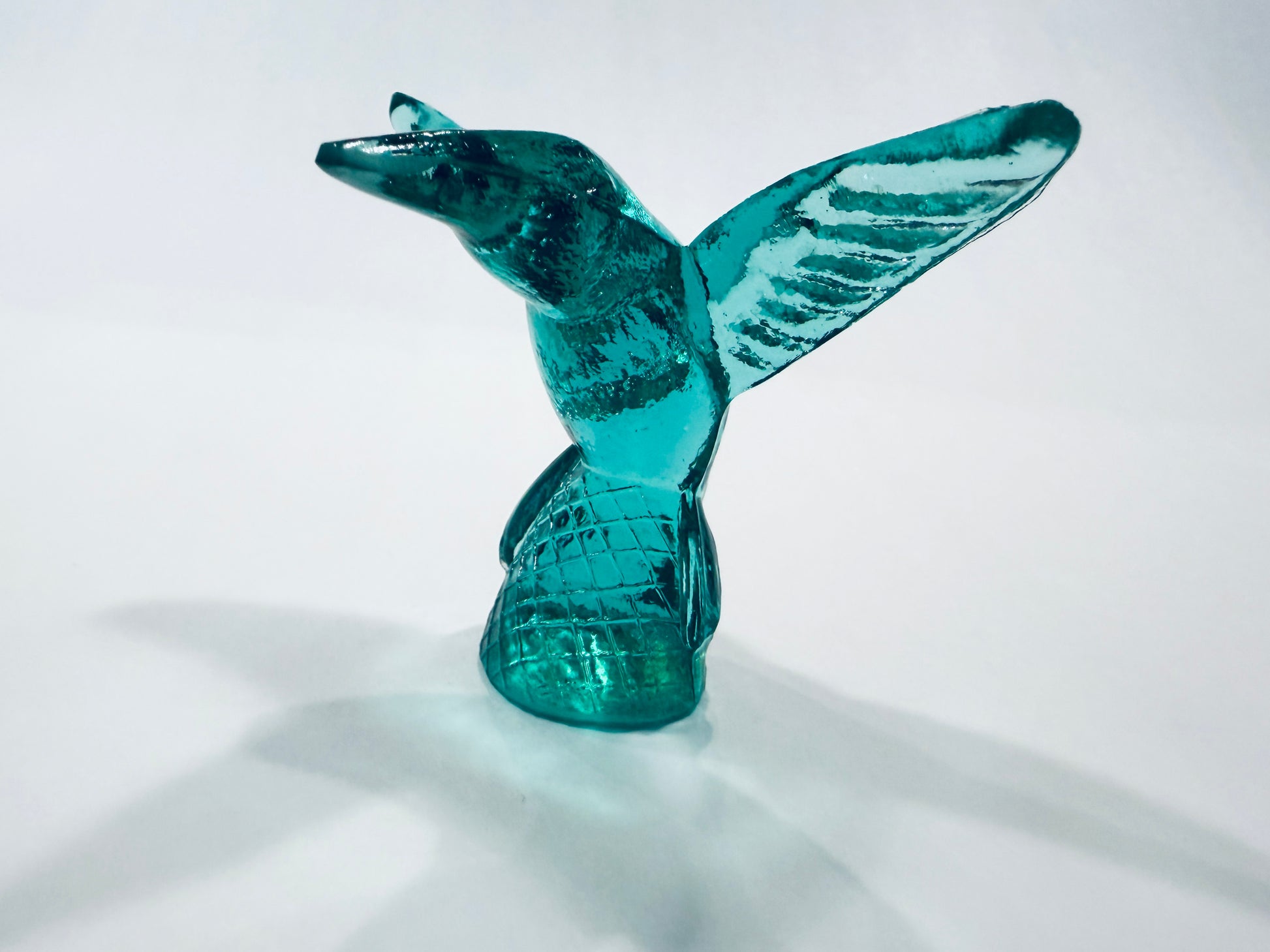 A translucent teal glass sculpture of a flying Hummingbird Made in Italy 
