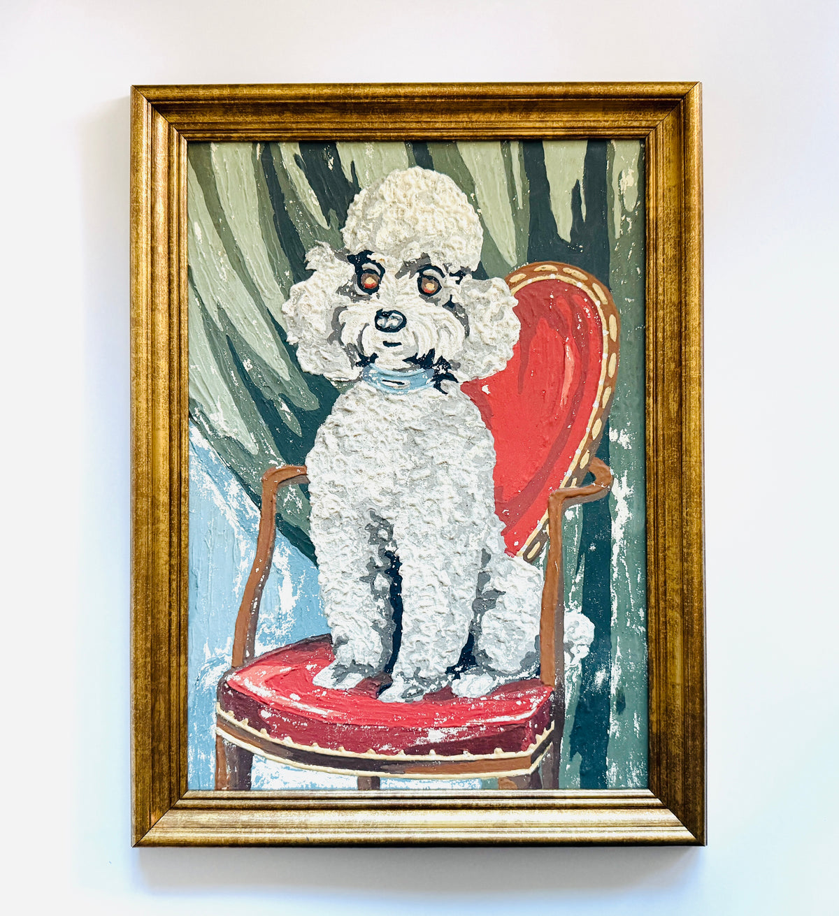 A painting of a fluffy white poodle sitting on a red chair, wall. features textured brushstrokes in green, blue, red, and white, in a gold frame.
