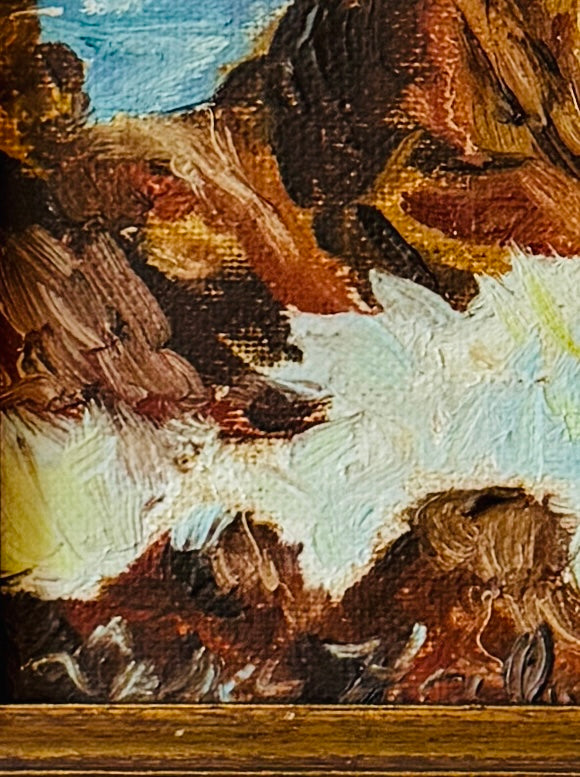 Close-up of a painting with abstract brushstrokes in brown, blue, and white.
