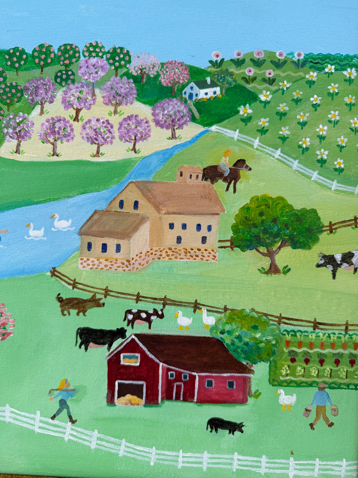A colorful folk art style painting of a farm landscape with a red barn, beige farmhouse, cows, ducks, horses, flowers, trees, and a blue river under a light blue sky.