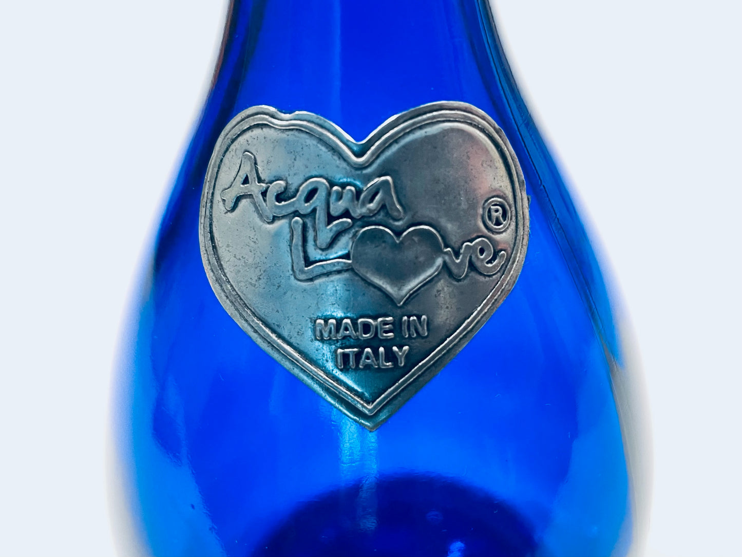 Aqua Love Blue bottle with a silver heart-shaped logo and 'Made in Italy' text 