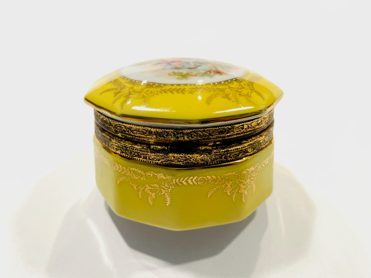 Yellow decorative box with intricate designs on a white background