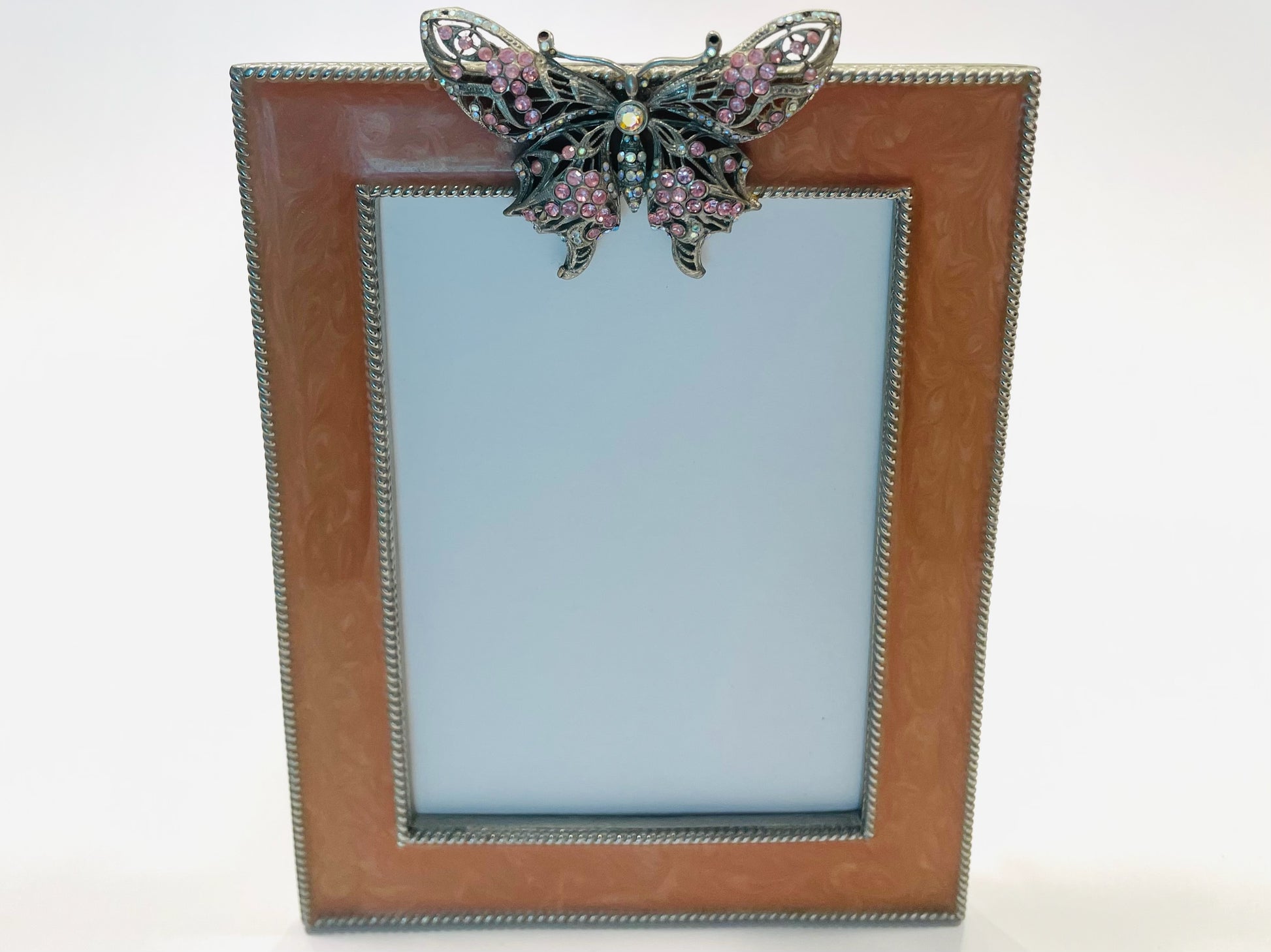 Decorative picture frame with a butterfly embellishment on a white background