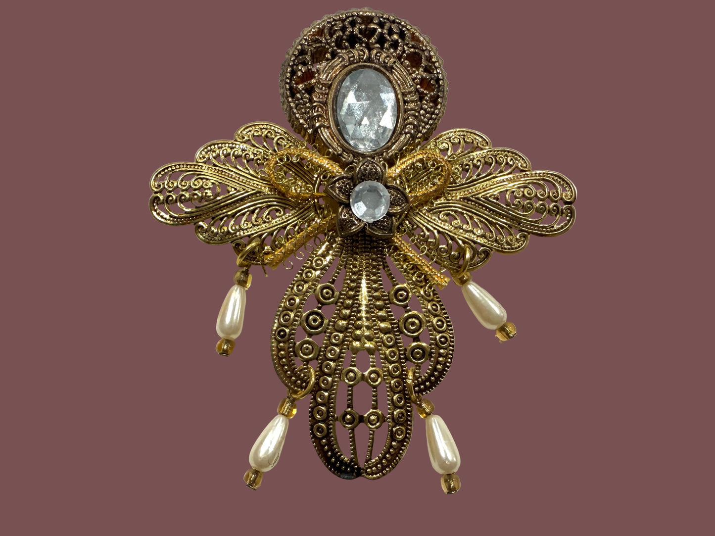 Decorative pnedant with gold filigree design and central cabochon gemstone 