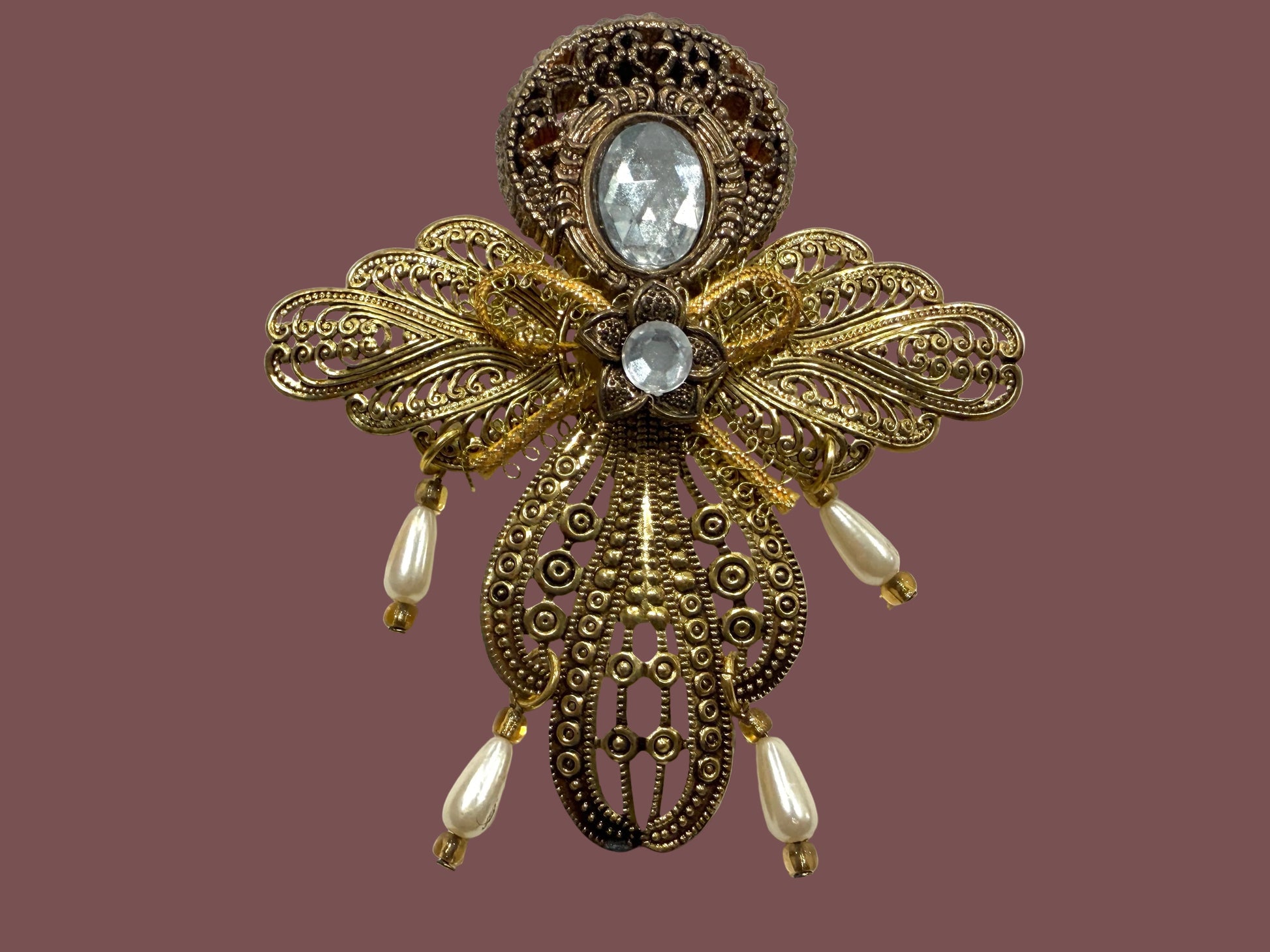 Decorative pnedant with gold filigree design and central cabochon gemstone 
