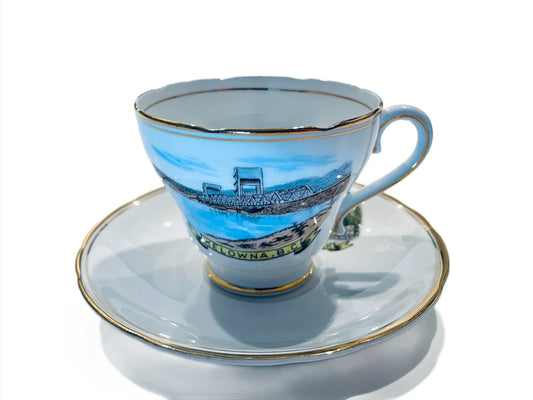 Royal Ascot bone china teacup and saucer with pictorial ornamentation featuring a blue and green design and the text 'Kelowna' on the cup.