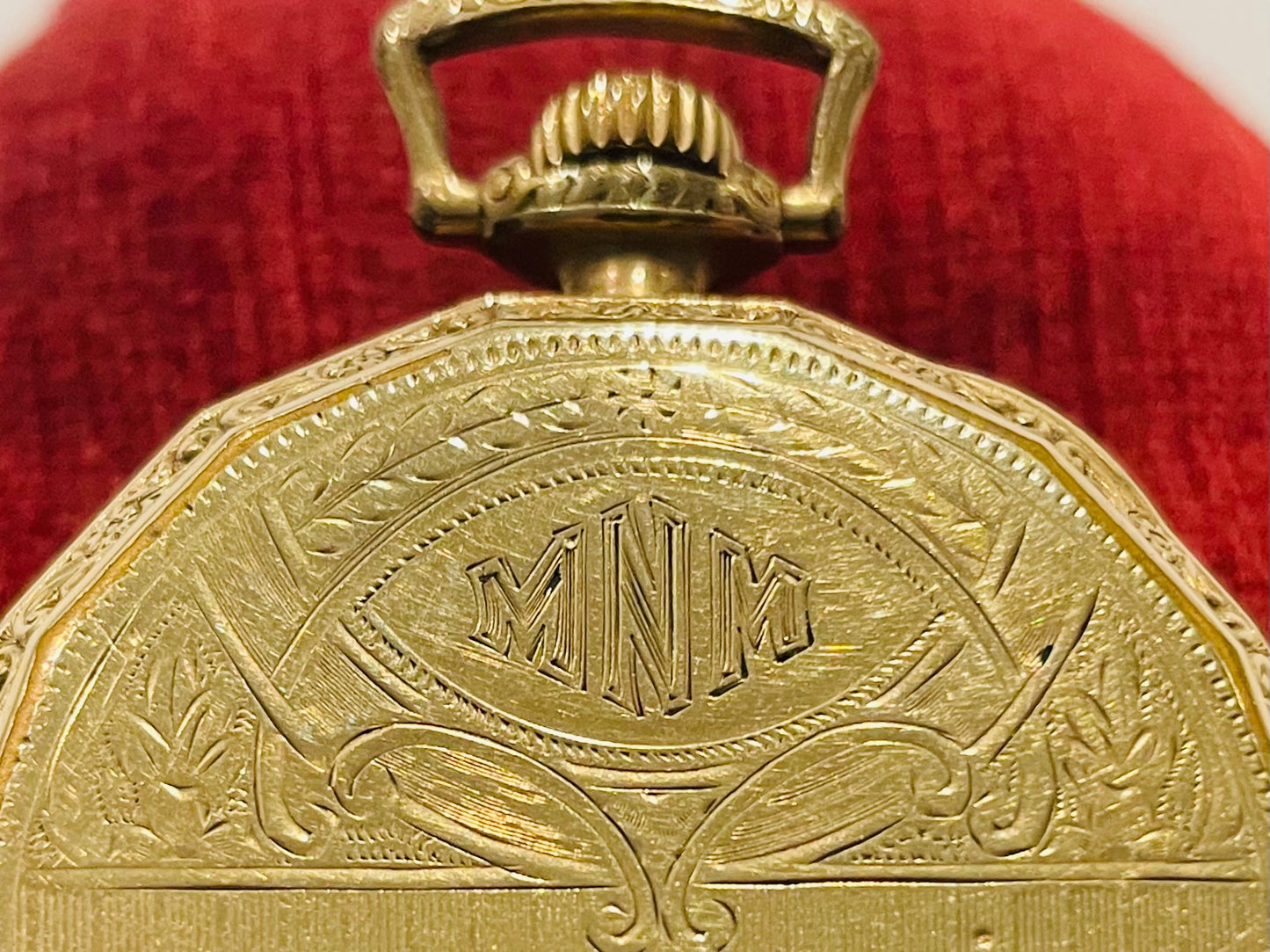 Close-up of a gold Elgin pocket watch with engraved design 