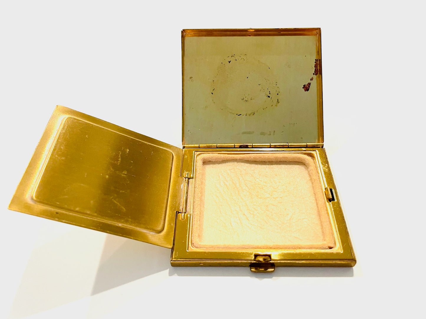 Gold compact mirror with a white background