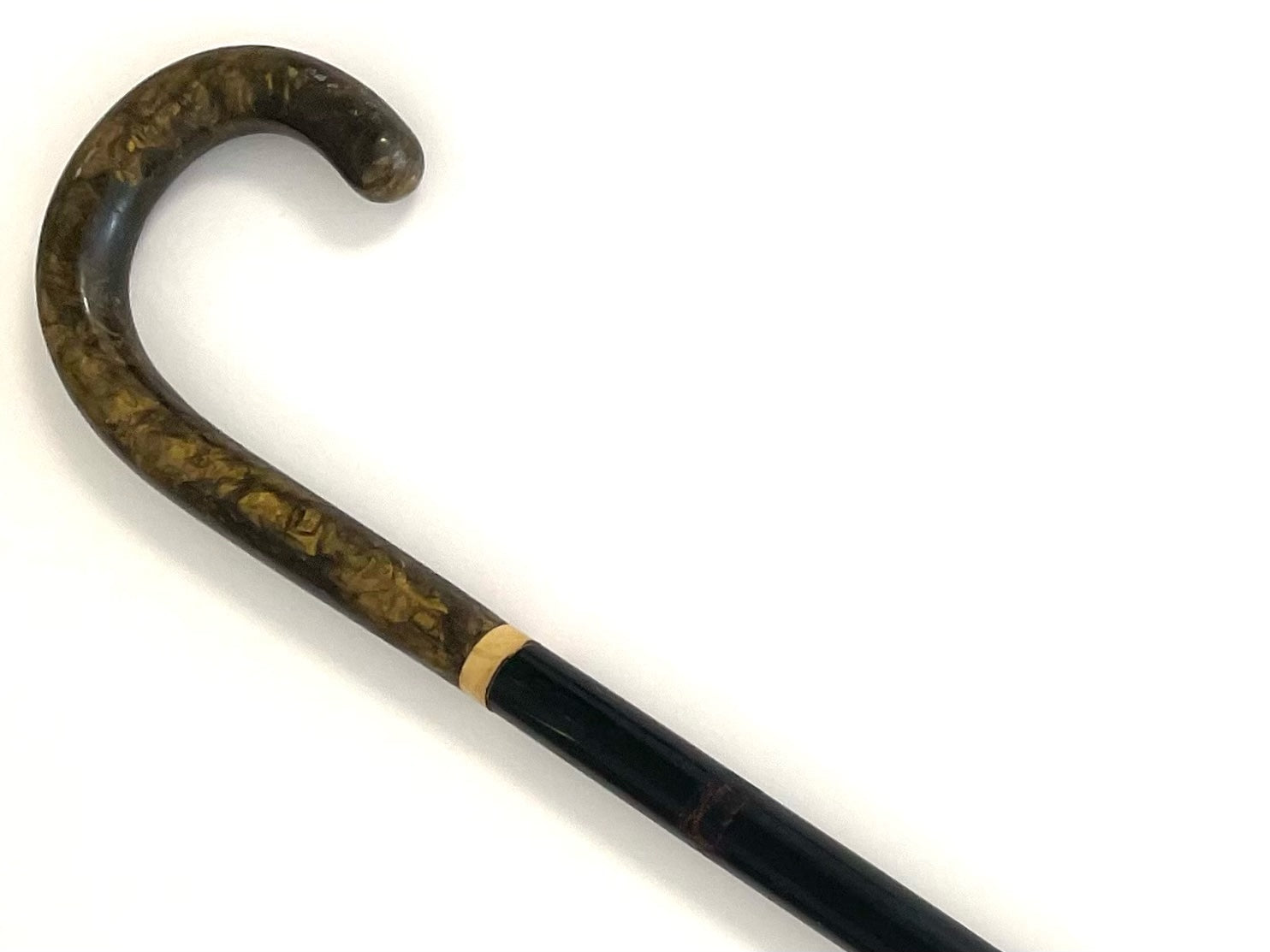 Decorative walking cane with a black handle and gold accents on a white background
