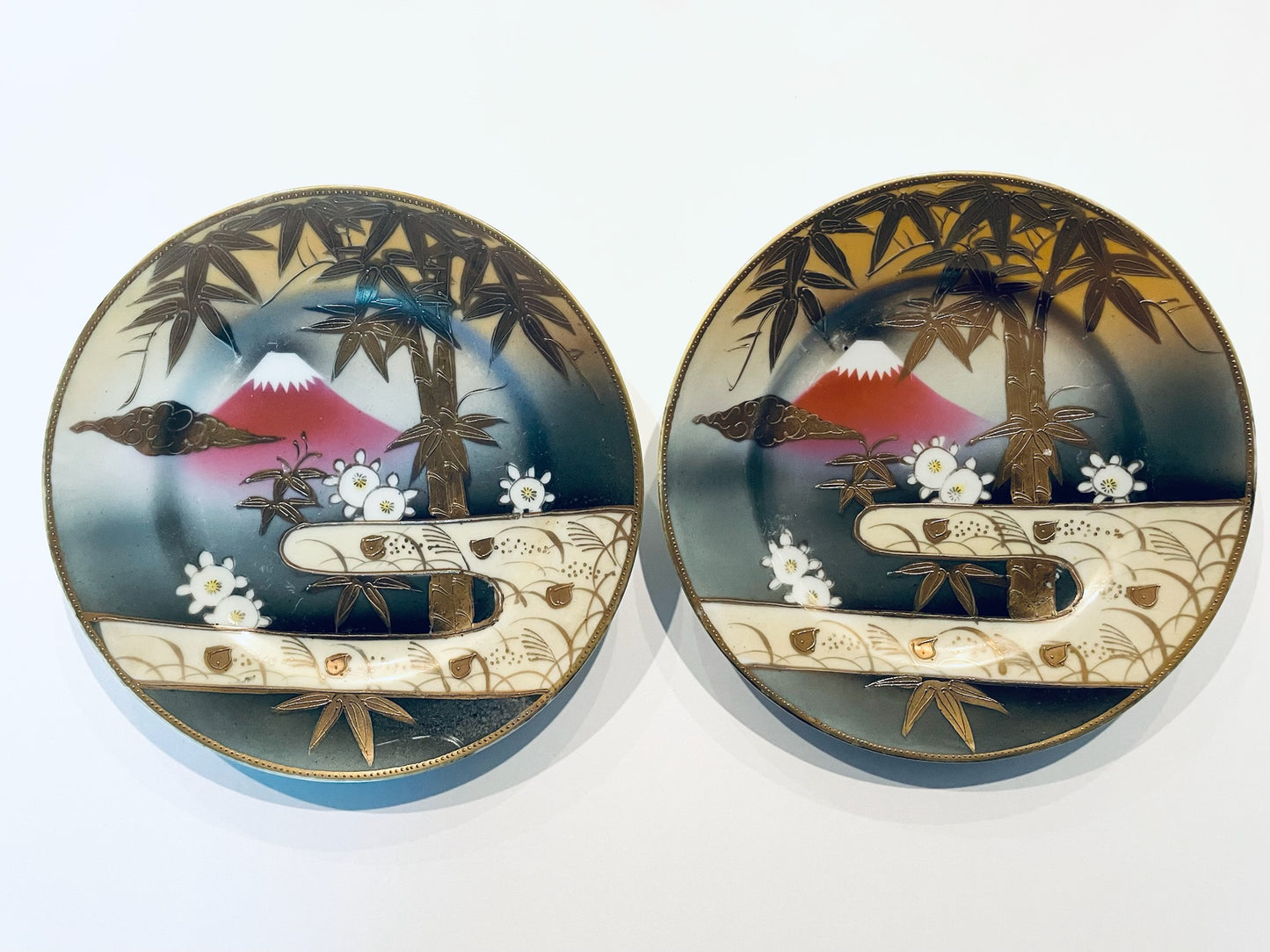 Two decorative Shofu plates with a scenic design featuring Japan Fuji mountains, bamboo trees, and flowers 