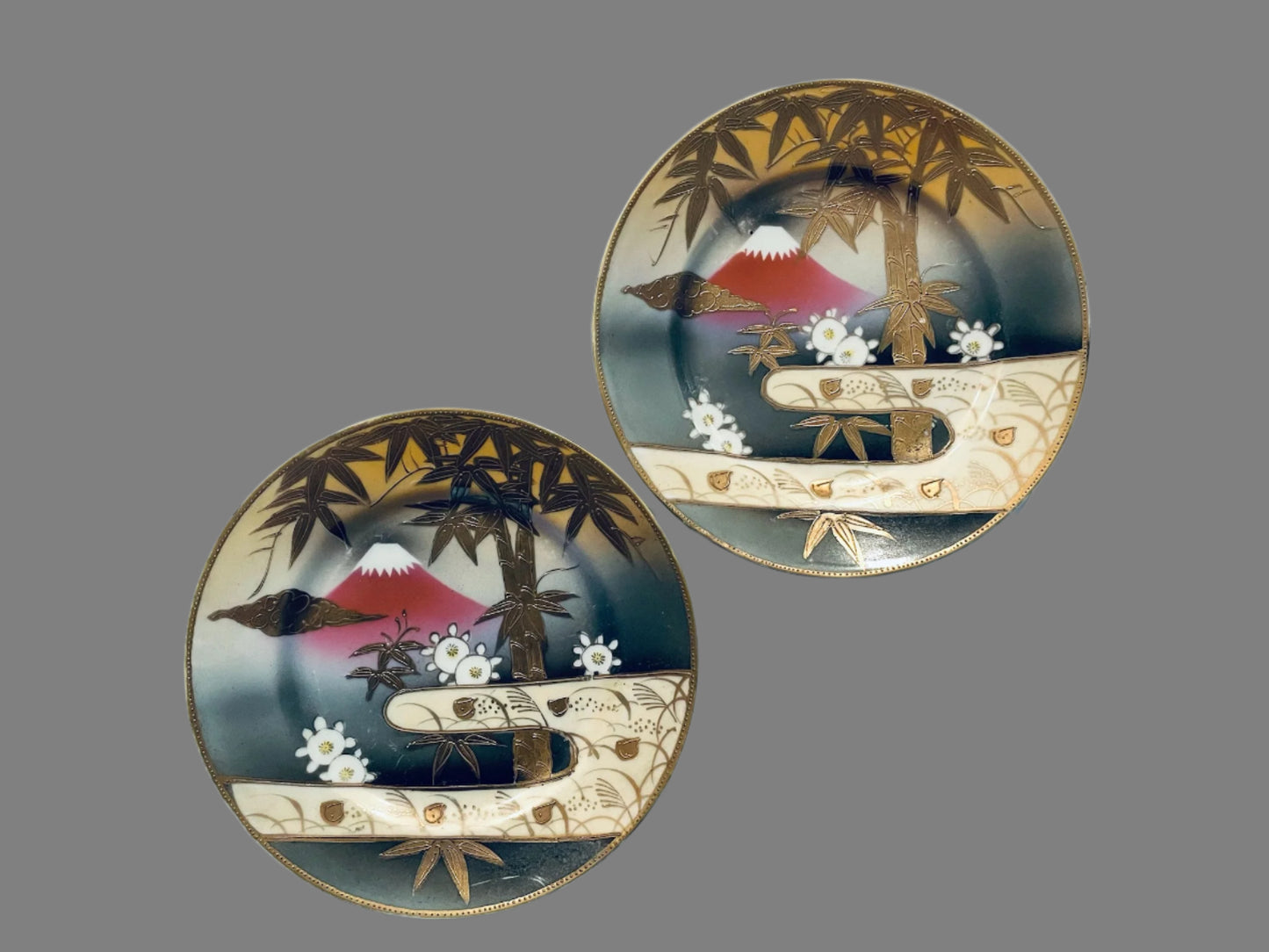 Two decorative plates with artistic designs mount fuji and gold bamboo 