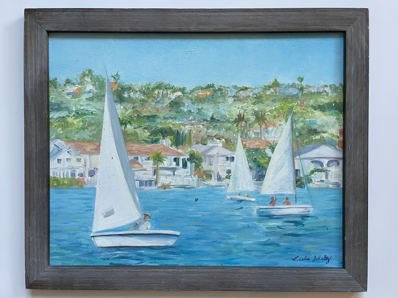 Leslie Schultz Sailing scene with sailboats on a body of water, with houses and trees in the background oil on canvas 
