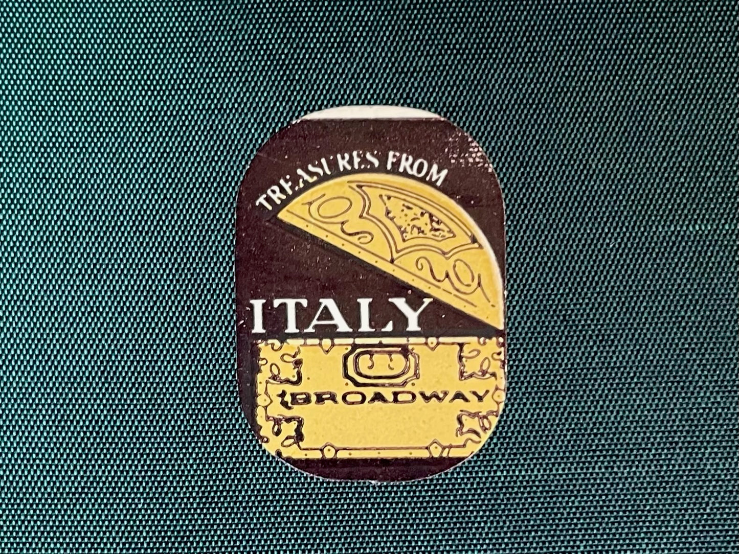 Decorative label with 'Treasures from Italy Broadway' text on a textured fabric background