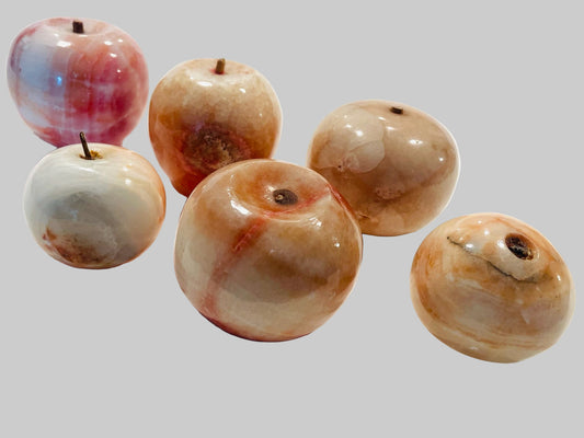 A collection of decorative stone marble fruits with stems