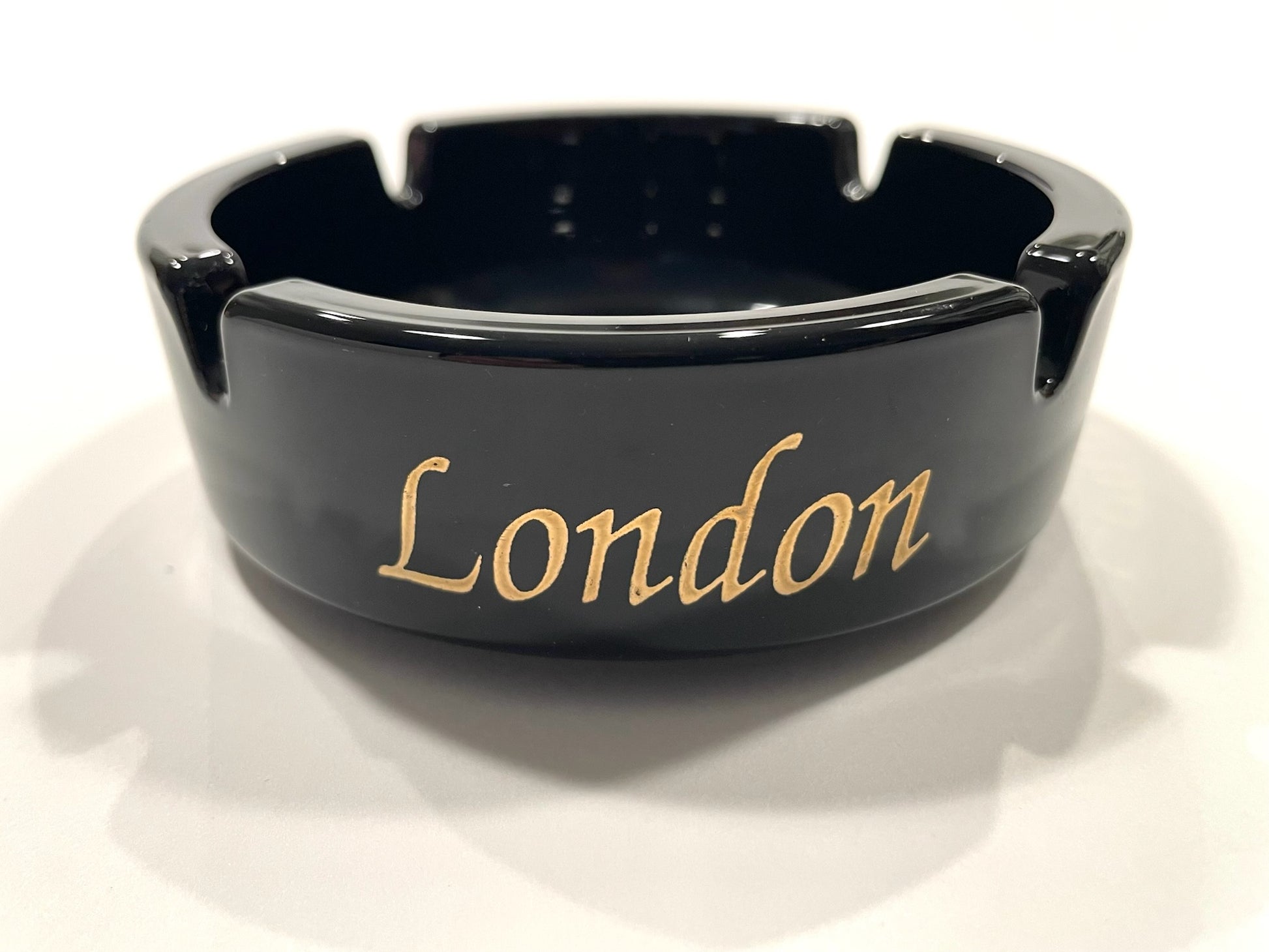 Black ashtray with 'London' written in gold 