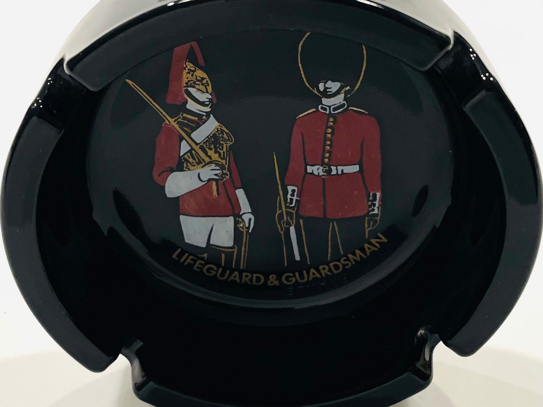 Black car air freshener with illustrations of a 'Lifeguard' and 'Guardsman' in red uniforms.