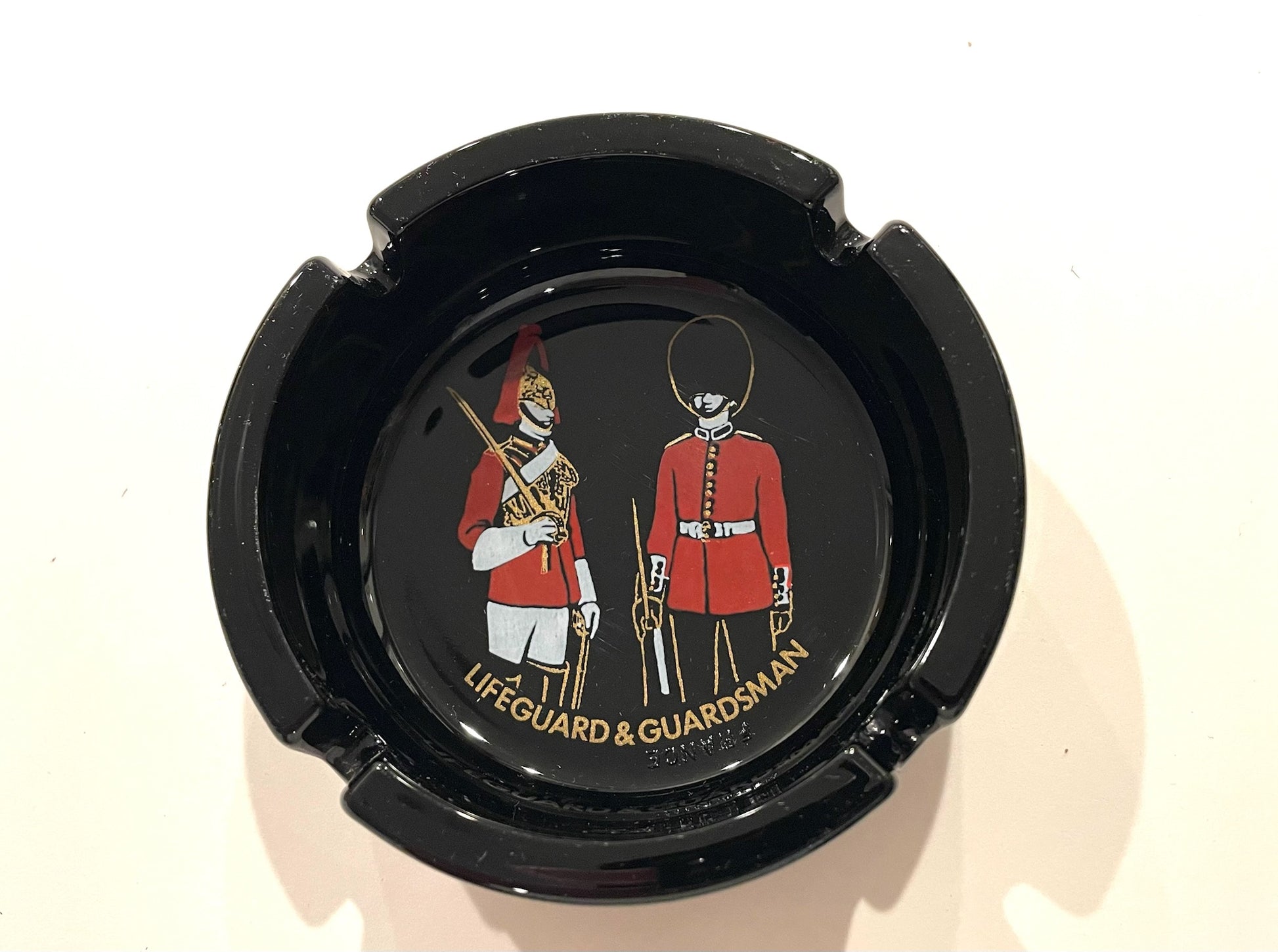 Black ashtray with illustrations of guardsmen and text Lifeguard & Guardsman France 