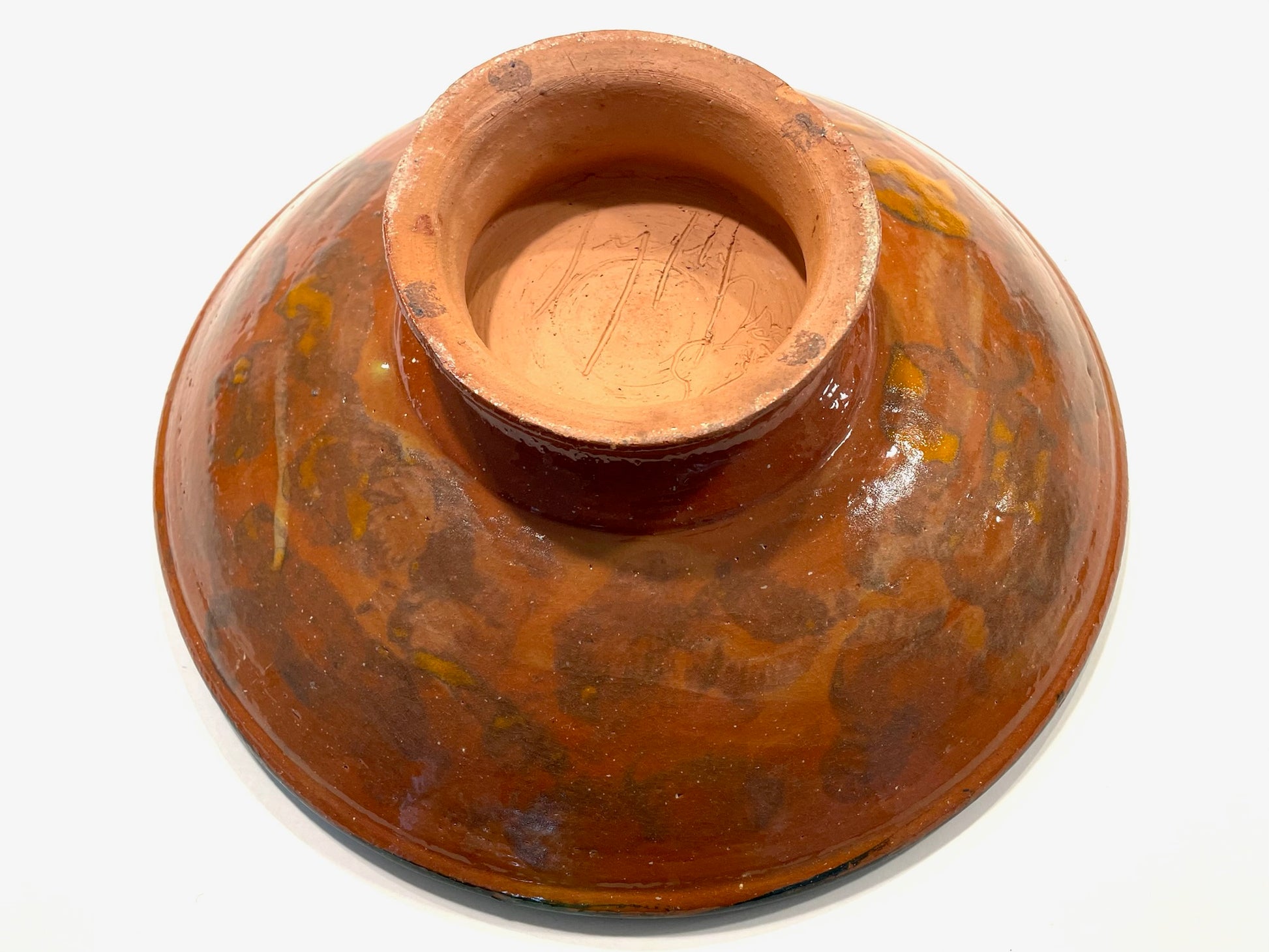 Terracotta bowl with decorative patterns on a white background