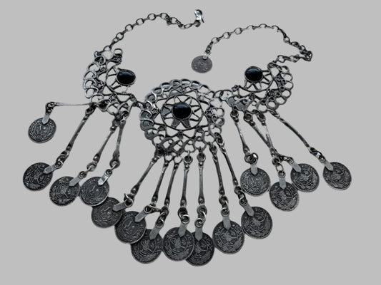 A silver filigree statement bib necklace with geometric metal pieces and onyx-like glass cabochons